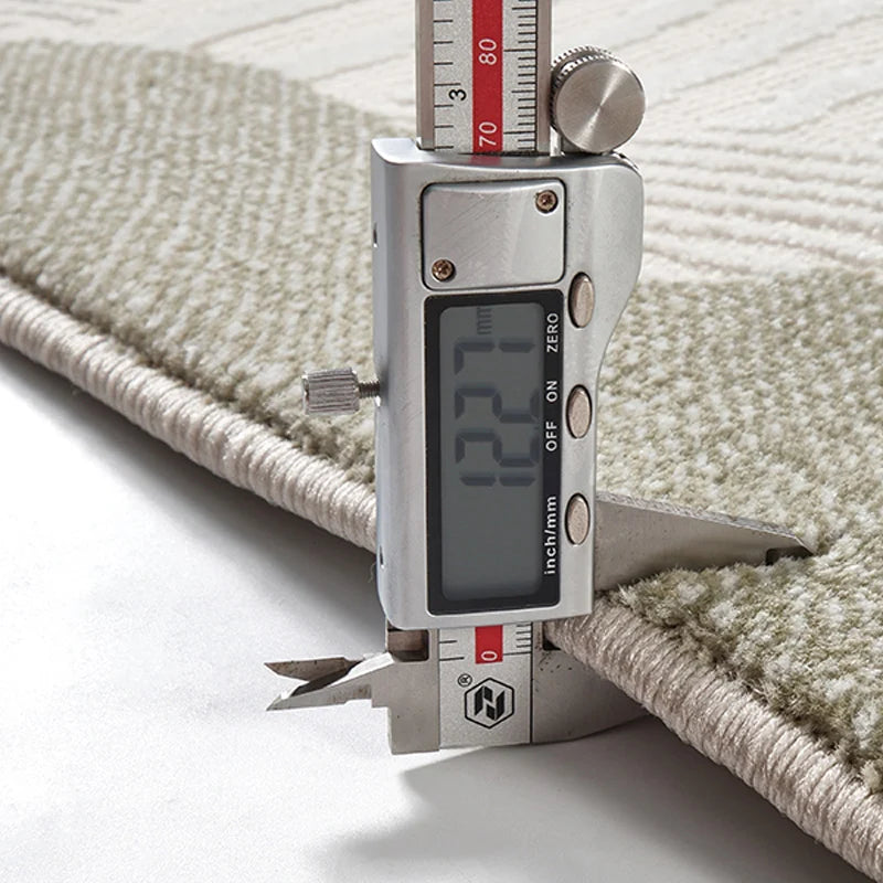 Digital caliper measuring the thickness of a 3D woven area rug, showing 12.7mm plush pile height, highlighting its dense texture, durability, and premium quality
