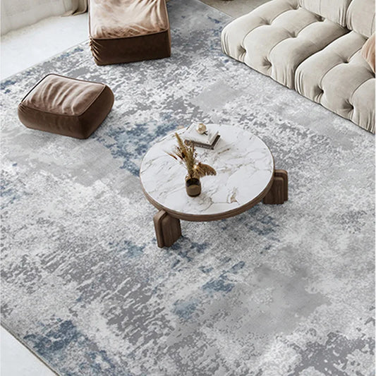 Abstract blue and grey area rug in a cozy living room with a marble coffee table and soft seating, ideal for modern interiors #color_gray