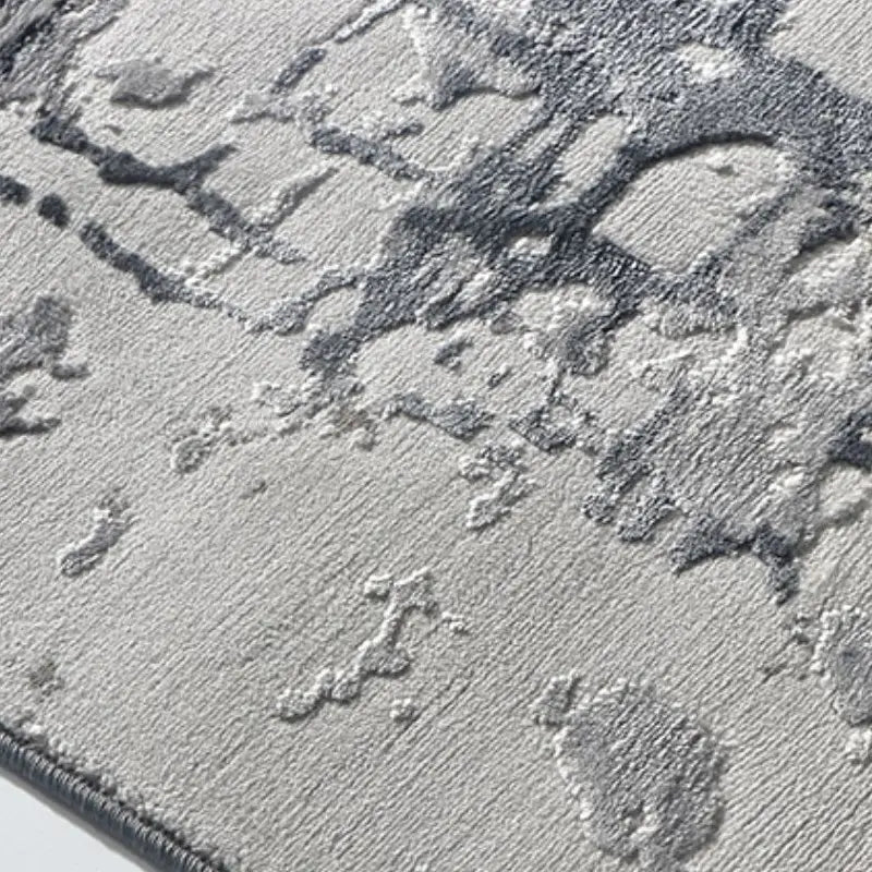 Detailed texture of an abstract gray area rug showing intricate patterns and soft raised fibers