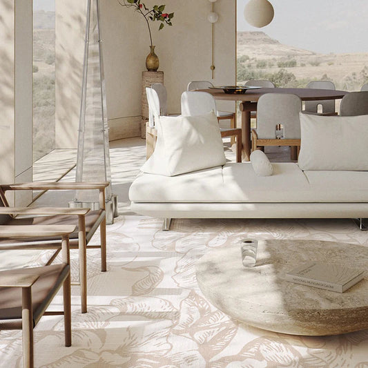 Beige floral patterned rug in a sunlit living and dining area with modern minimalist furniture