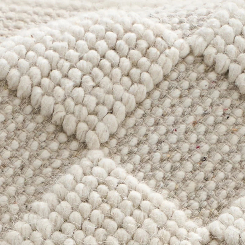 Close-up of the intricate wool weave texture on a handwoven rug, showcasing its natural and detailed craftsmanship #color_Beige Texture
