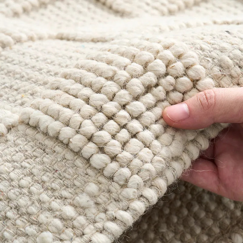 Close-up view of a handwoven wool rug showcasing the intricate texture and natural craftsmanship #color_Beige Texture
