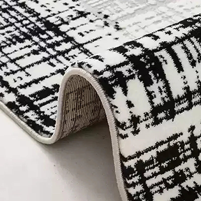 Detailed view of a modern black-and-white area rug with a textured pattern and durable folded edges for long-lasting quality #color_Ivory