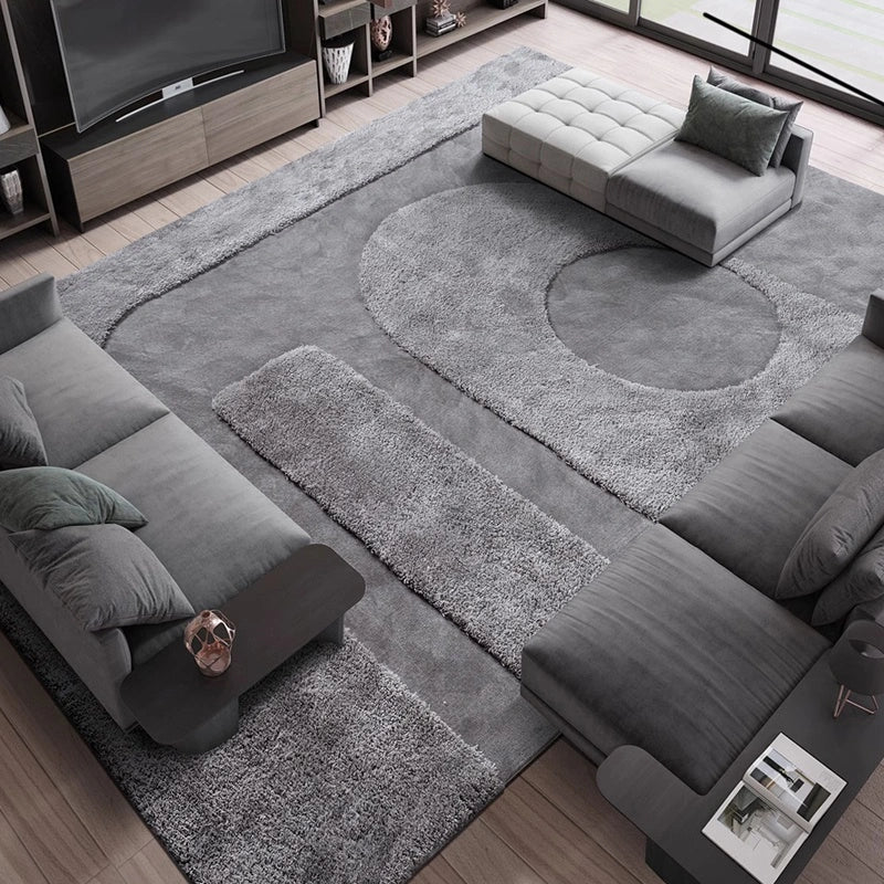 Geometric gray rug in a modern living room with dark sofas and a tufted ottoman #Shape_Rectangle