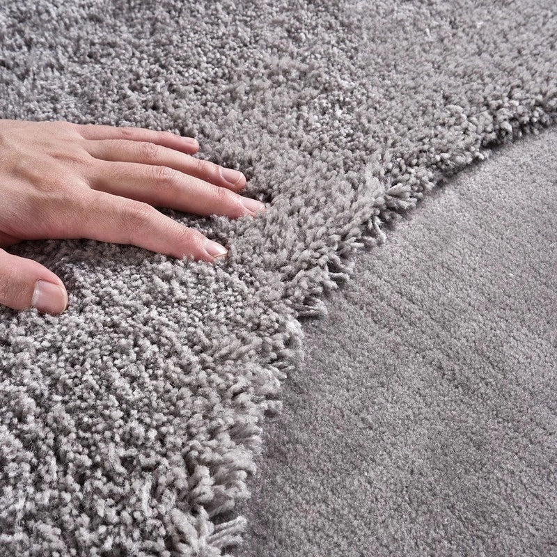 Close-up of a hand touching the soft texture of a gray rug #Shape_Round