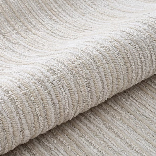Ivory gray linear textured area rug rolled to show thick woven texture and soft neutral surface