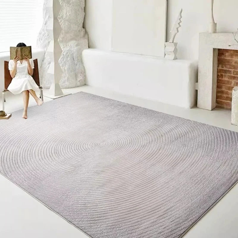 A minimalist living room featuring a gray rug with a concentric circle design, adding subtle elegance and texture to the space #texture_Harmonic Circle