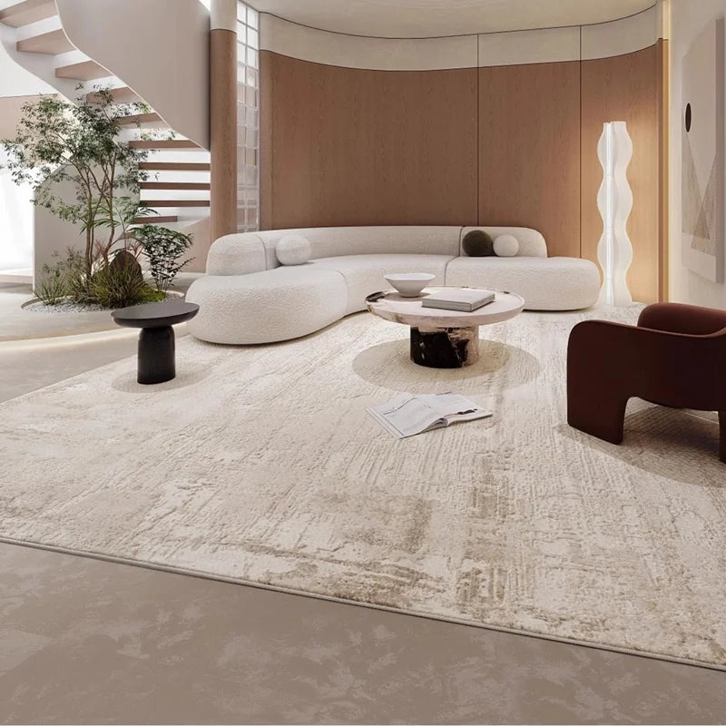 Modern living room with a beige area rug, curved white sofa, and contemporary furniture