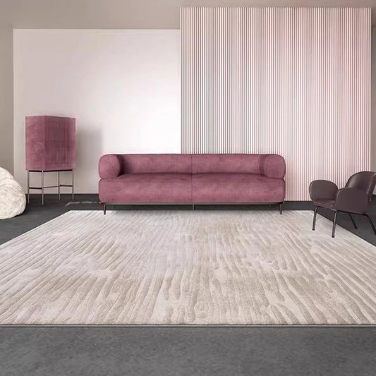 Modern minimalist living room featuring beige textured rug with abstract wave pattern, mauve sofa, and contemporary decor