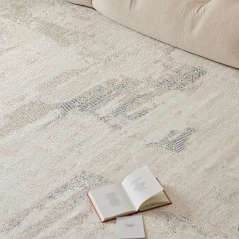 A cozy, soft-textured rug with abstract neutral patterns, styled with an open book for a tranquil reading moment in a serene living space