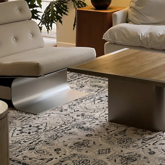 Close-up of Persian-style rug under a modern coffee table and lounge chair.