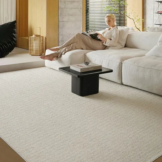 Minimalist living room featuring a loop-pile wool blend rug with upgraded density, paired with an elegant light gray sofa and black coffee table