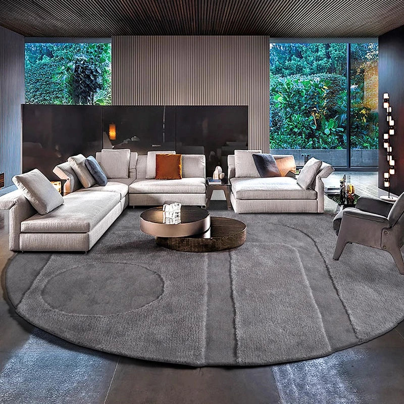 Round gray rug in a modern living room with a sectional sofa and a circular coffee table #Shape_Round