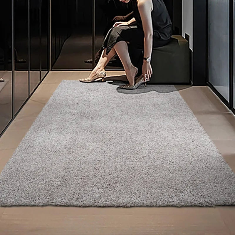 Gray shaggy rug in a modern dressing room with a seated woman adjusting her shoes #color_Light Gray