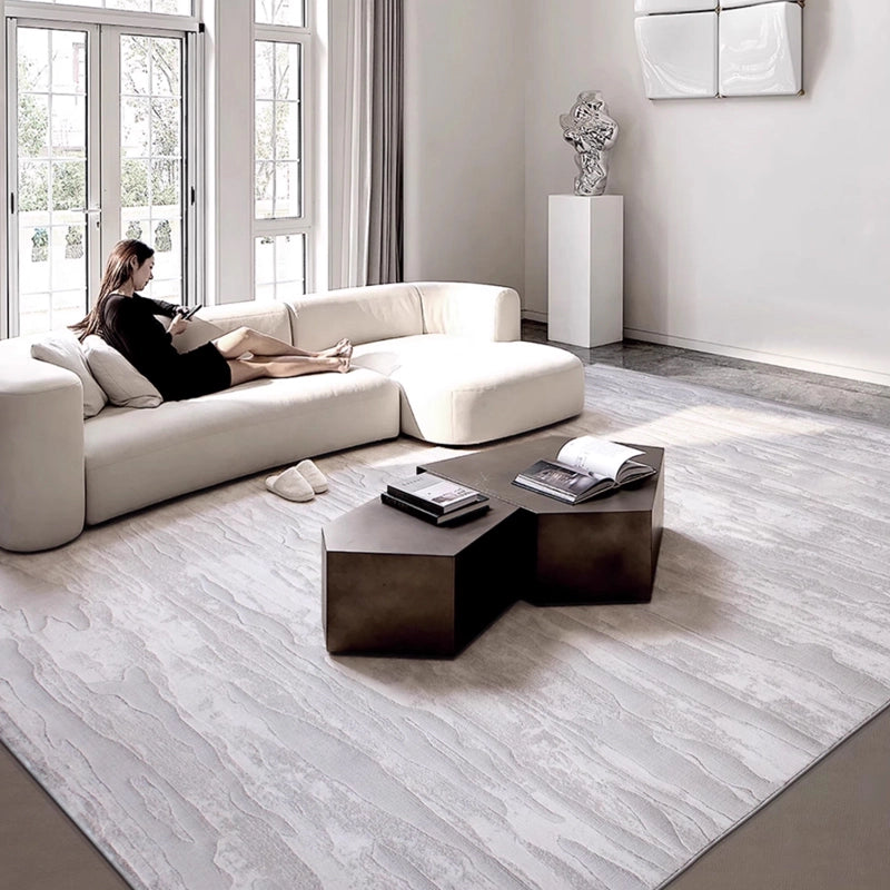 Textured gray rug in a modern minimalist room with a white sectional sofa and geometric coffee tables #Texture_Linear Drift