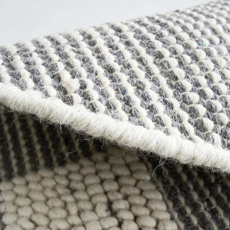 Close-up of a checkered wool rug edge with textured weaving #color_Black & White Check