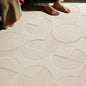 Close-up of cream 3D geometric rug with embossed circles and arcs, made from diatom fiber with waterproof texture