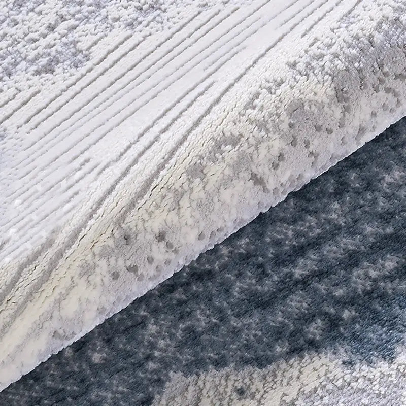 Soft thick pile texture of blue and grey abstract area rug, dense and comfortable surface detail
