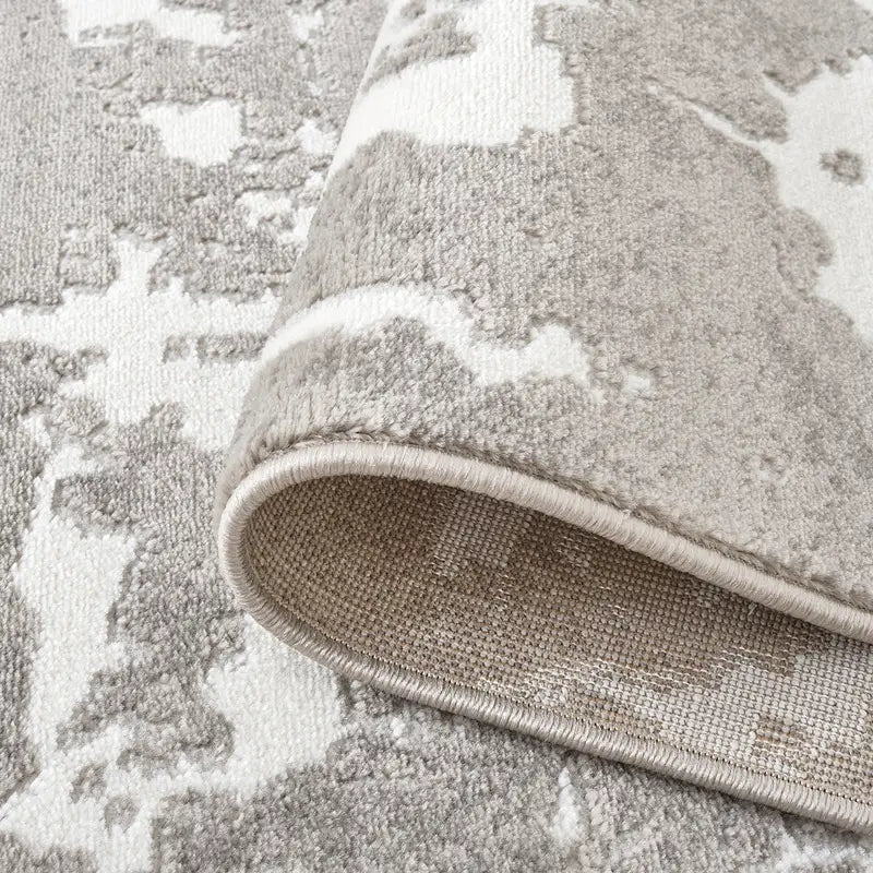 Detailed close-up of the abstract rug's edge showcasing durable stitching and high-quality texture #color_white