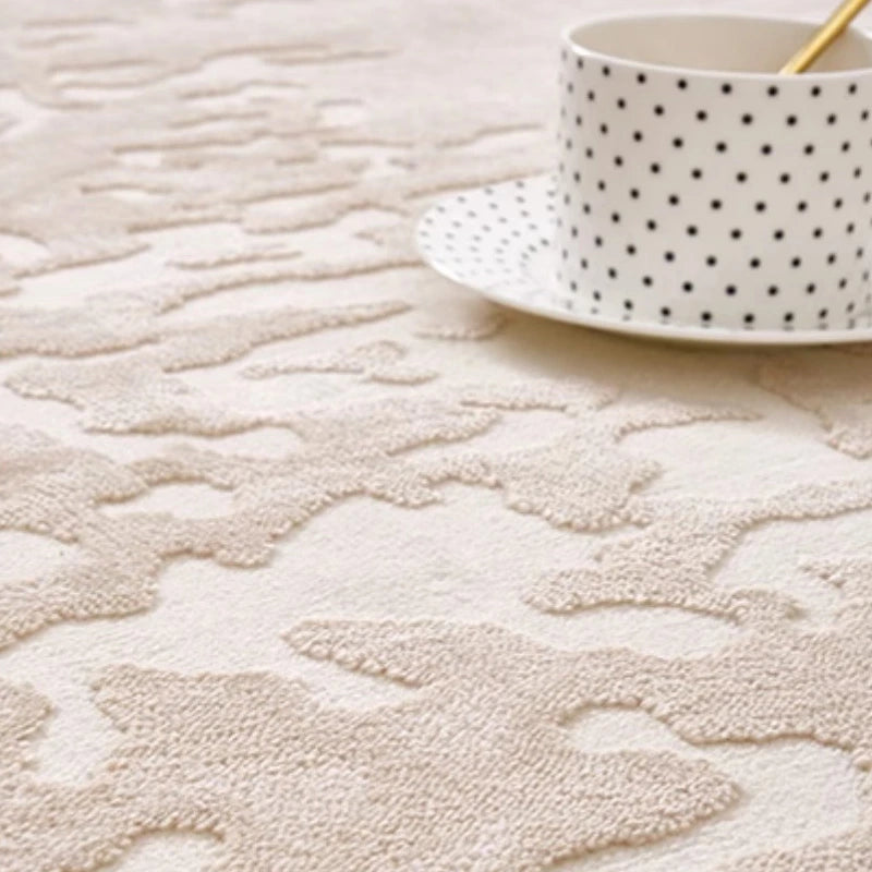 Close-up of a beige abstract rug with a soft textured surface, featuring intricate raised patterns, next to a polka dot teacup #Texture_Mist