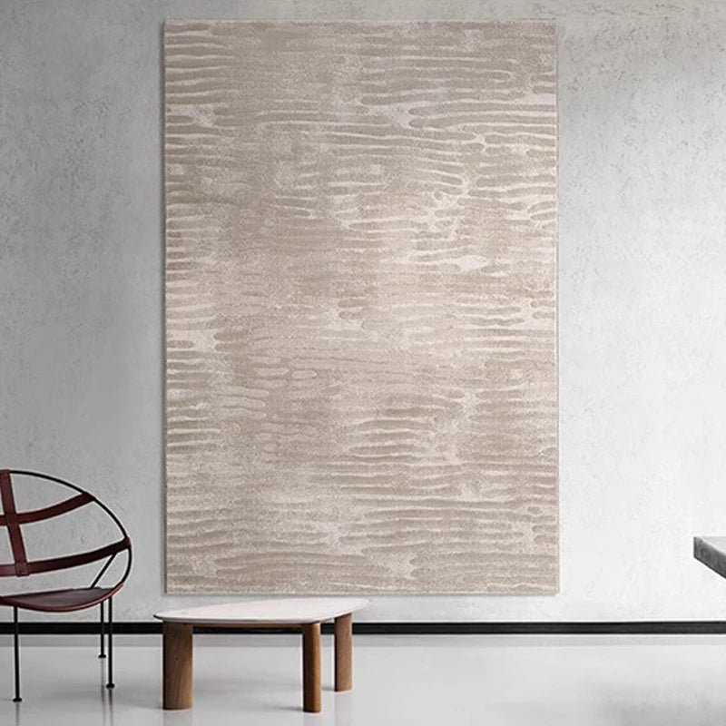 Modern interior featuring beige abstract wave-pattern area rug displayed as wall art, minimalist furniture, and contemporary decor