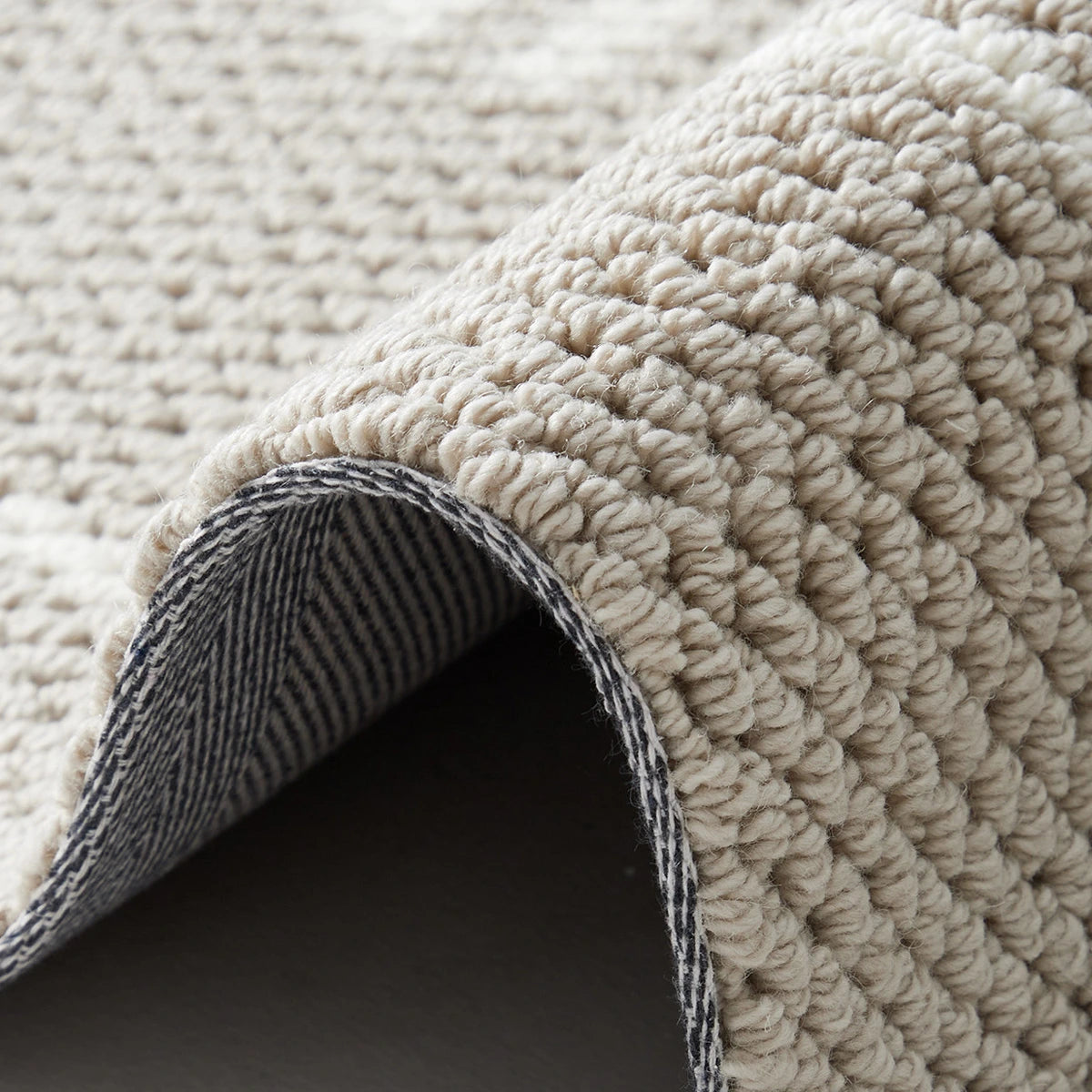 Beige edge weave rug with a thick looped texture and reinforced woven finish