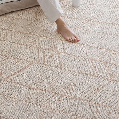 Beige geometric leaf rug with a dense loop surface shown underfoot for a stable everyday feel