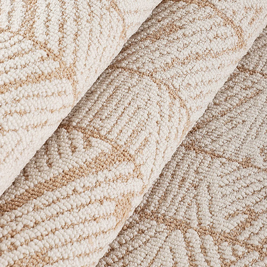 Rolled edge detail of a beige geometric leaf rug with a dense high-low loop woven surface