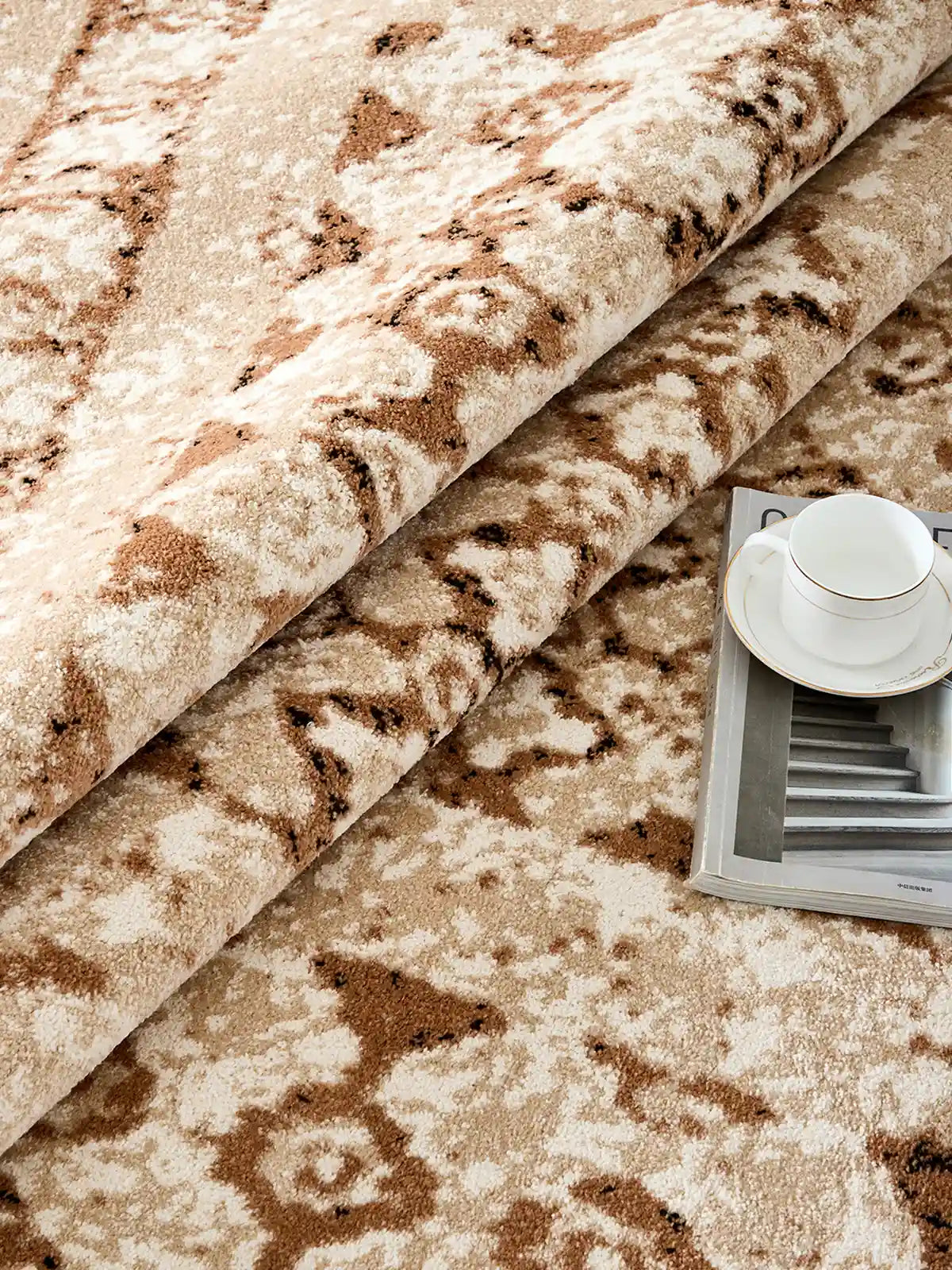 Folded beige Persian-style rug showing dense pile texture and elegant pattern