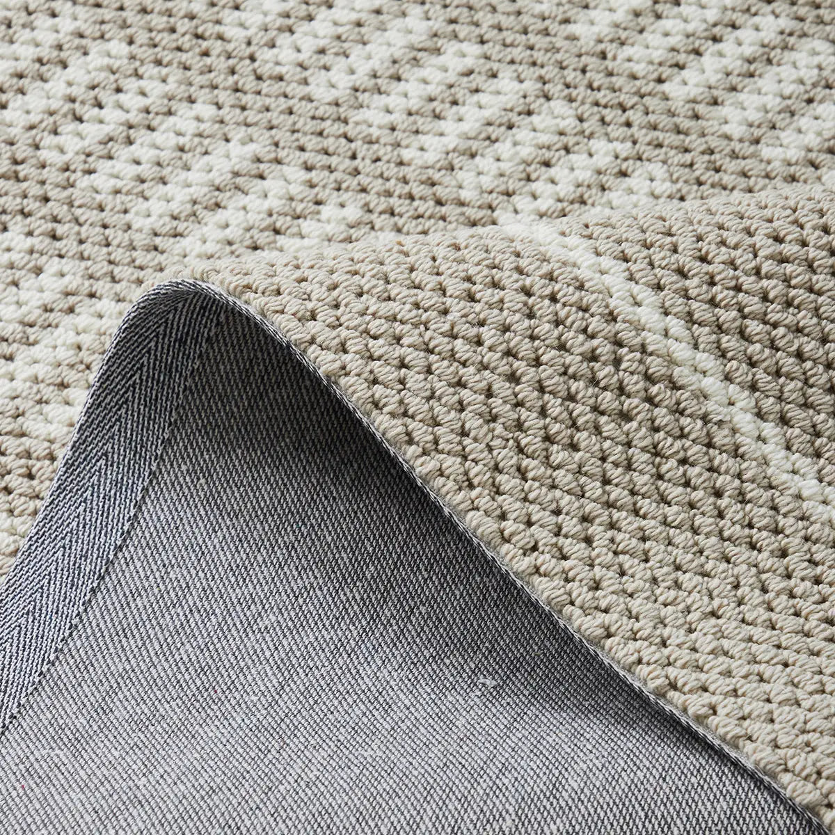 Beige rug backing detail showing a durable woven underside and structured construction