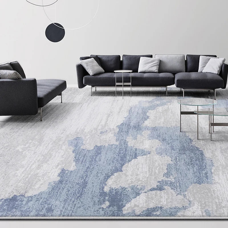 Blue-gray abstract rug in a modern living room with a dark gray sectional sofa and glass tables  #color_blue