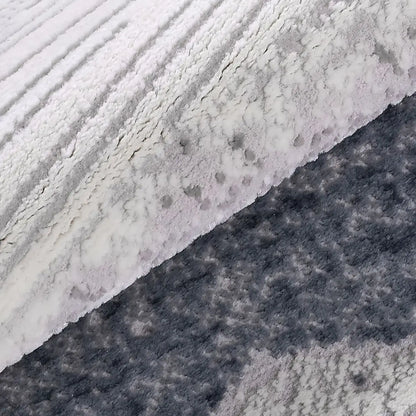 Blue-gray abstract area rug folded texture detail showing soft raised pile and layered gray blue pattern.