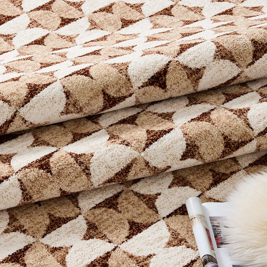 Close-up of a brown geometric area rug showing its soft textured surface and thick woven construction.