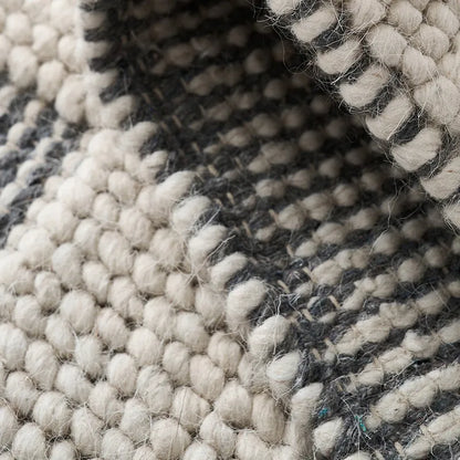Detailed close-up of the black and white checkered wool rug, highlighting its handwoven texture and natural fibers #color_Black & White Check