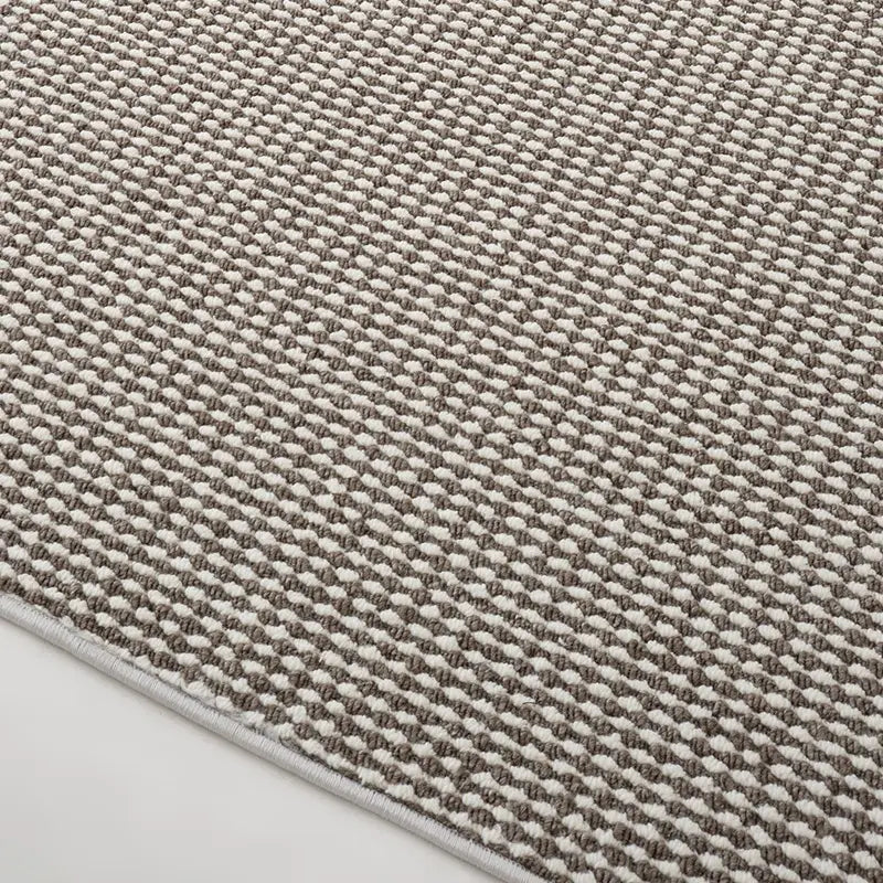 Detailed view of taupe and cream loop pile wool blend rug with precision edge finishing
