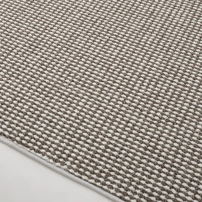 Detailed view of taupe and cream loop pile wool blend rug with precision edge finishing