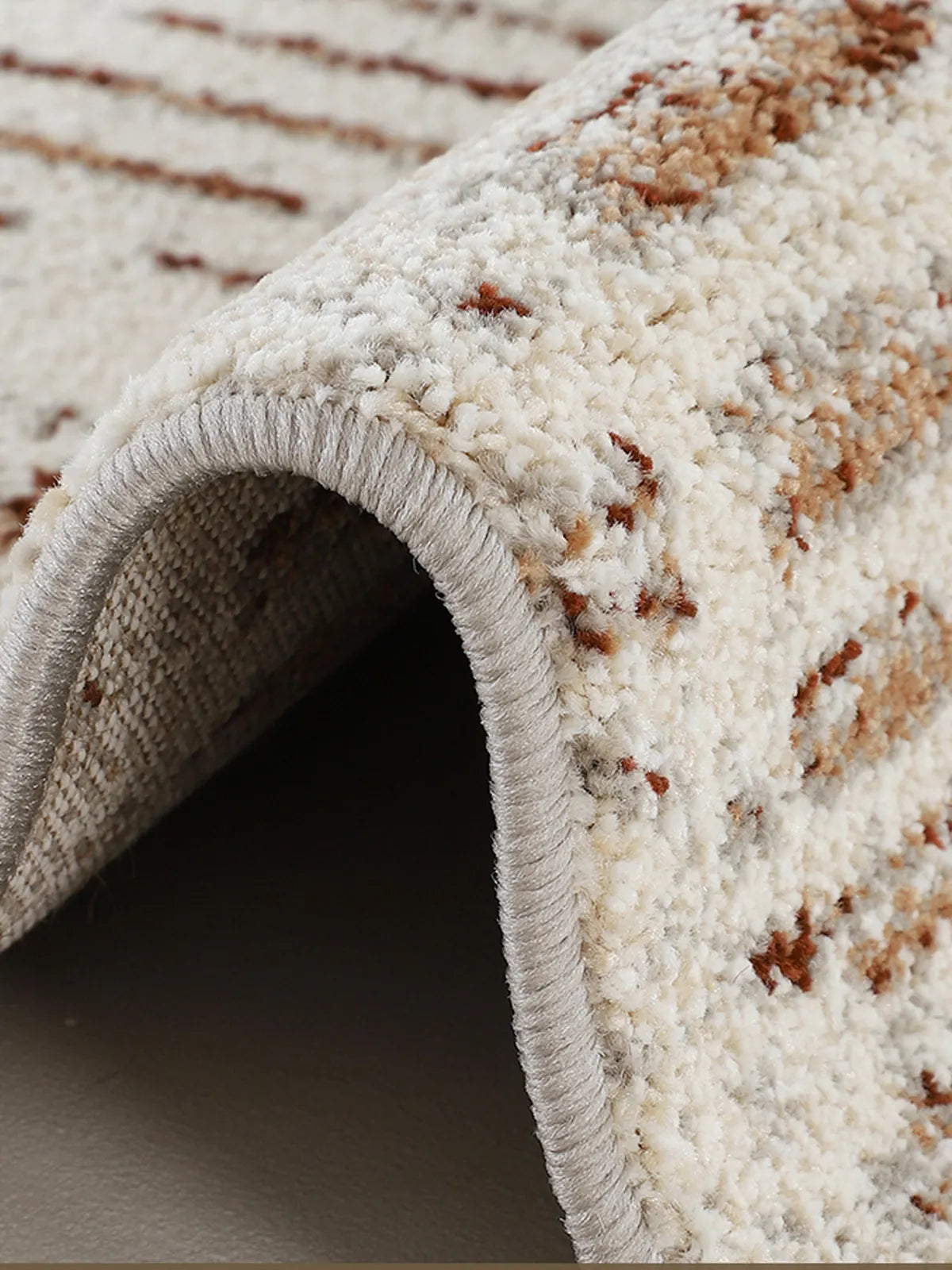 Close-up of modern area rug with soft, high-pile texture and clean neutral geometric design