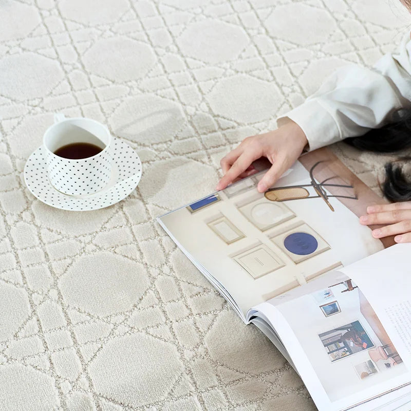 A close-up of a beige rug with intersecting line patterns，a hand flipping a magazine#Texture_Crosshatch