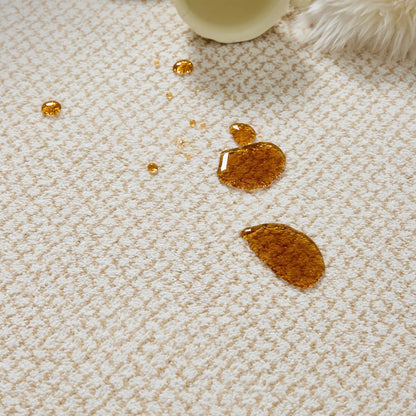 Close up of cream beige rug texture with water-based spill beading on the surface