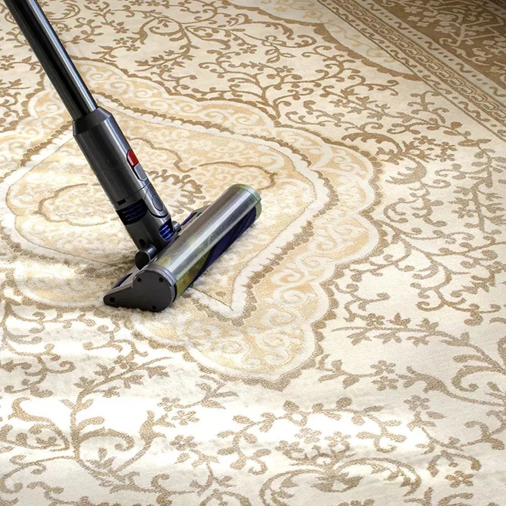 Vacuum cleaning a cream beige Persian area rug with a dense woven surface for easy everyday maintenance.