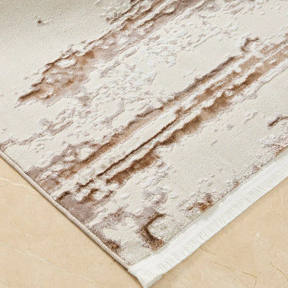 Close-up of cream brown distressed abstract area rug showing bound edge and textured surface