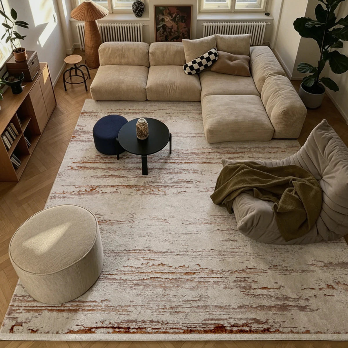 Cream brown distressed abstract area rug in a warm modern living room with neutral furniture