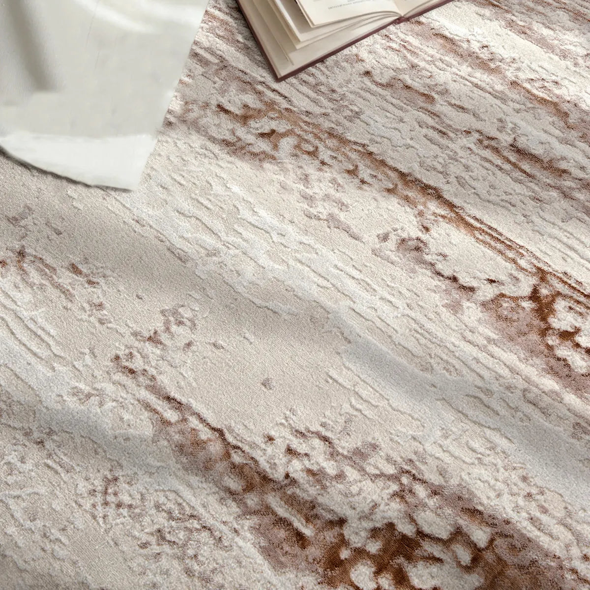 Surface detail of ivory rust brown distressed abstract area rug with warm brown accents and soft texture