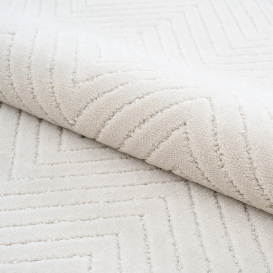 Close-up of cream geometric rug showing soft textured surface and subtle linear pattern