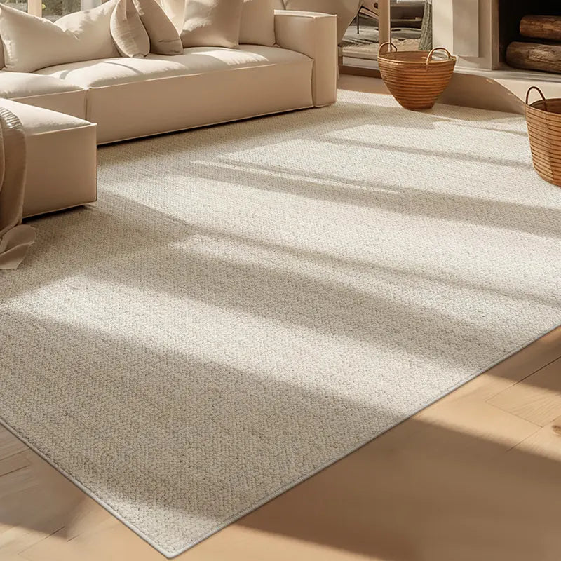 Close-up of a dense boucle-textured wool blend rug in a sunlit modern living room with cream sofa and woven baskets
