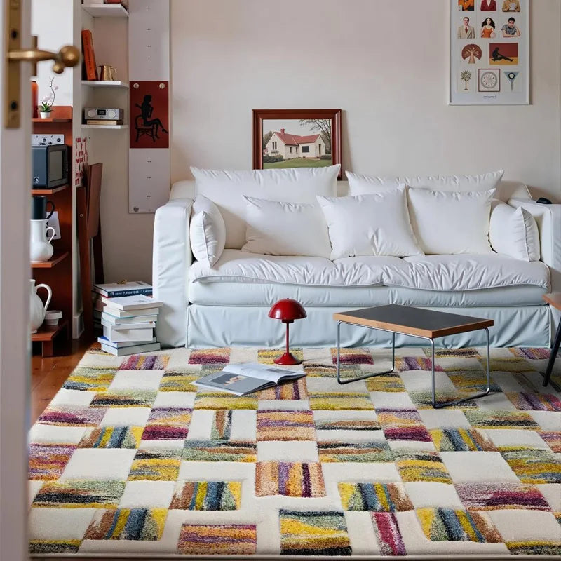 Colorful dopamine patchwork rug in a cozy modern living room with a white sofa and red lamp