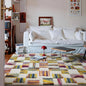 Colorful dopamine patchwork rug in a cozy modern living room with a white sofa and red lamp