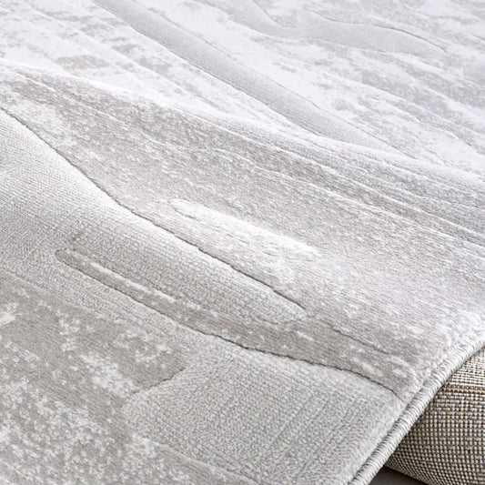 Close-up of a thick gray area rug showing subtle texture and clean edge finish