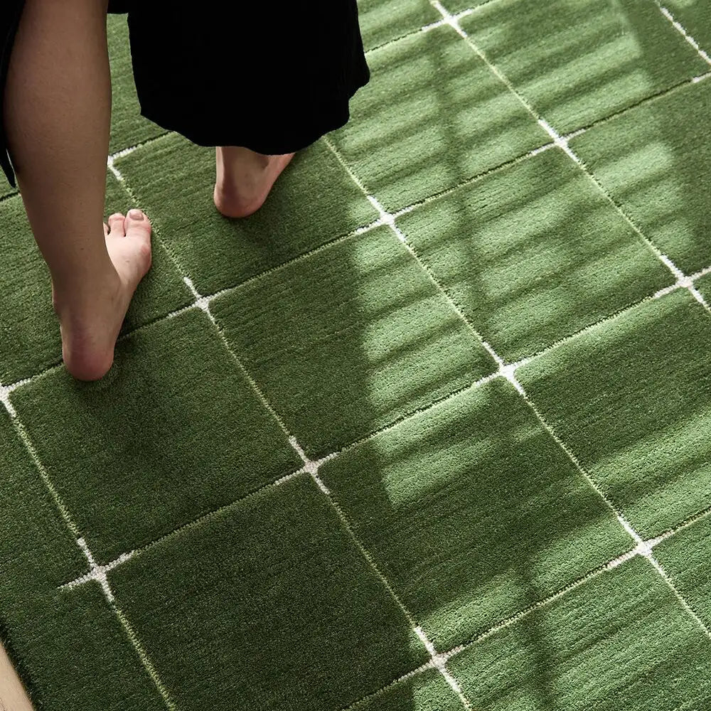 Close-up of green grid rug underfoot, showing a soft cushioned texture