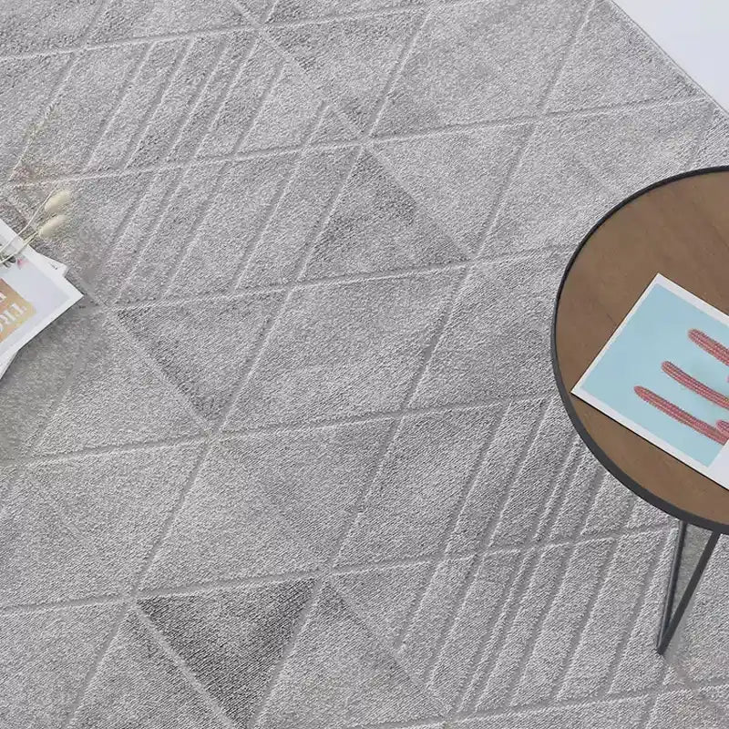 Close-up of a grey geometric-patterned area rug showcasing intricate texture, high-density weave, and modern minimalist design